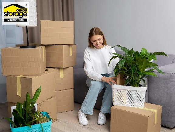 Alquilar Minibodegas en Quito para hogares Mujer organizando cajas y plantas